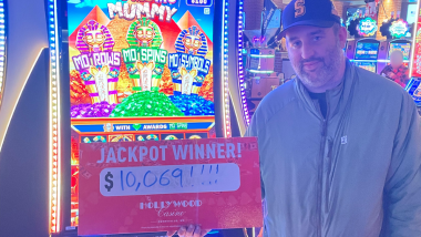 A picture of a Guest who won a jackpot holding up a big check!