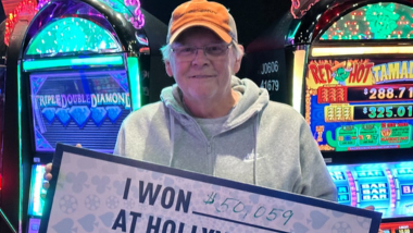 A picture of a Guest who won a jackpot holding up a big check!