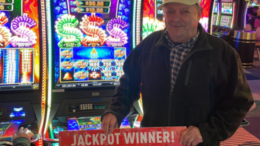 A picture of a Guest who won a jackpot holding up a big check!